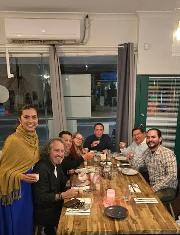 Friends sharing a Peruvian dinner at a long table at Ají & Limón